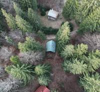 Aerial view of a cabin in Krpáčovo surrounded by dense forest and trees.