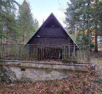 A wooden cabin surrounded by trees on Krpáčovo street in Krpáčovo at dusk.