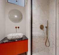 A bathroom with a shower, a marble sink on a red cabinet in a 4-room apartment.