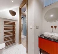 A stylish bathroom with a mirror, sink, and decorative radiator in a 4-room apartment.