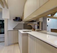 A kitchen in a 4-room apartment with white cabinets, built-in appliances, and a floor with a wooden decor.