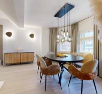 Dining area with an oval table, various chairs, and pendant lamps in a 4-room apartment.