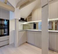 A kitchen in a 4-room apartment with a cooktop, oven, and floor with a wooden decor.