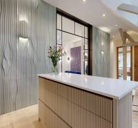 Interior of a 4-room apartment with a designer wall, light furniture, and flowers on the table.