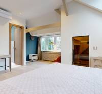A bright bedroom in a 4-room apartment with air conditioning and a wooden decor floor.