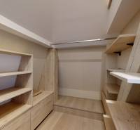 A bright storage space with shelves and a wood-patterned floor in a 4-room apartment.