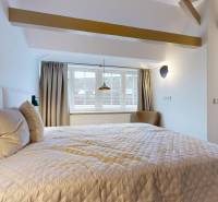 Bedroom in a 4-room apartment with a large bed and a skylight.