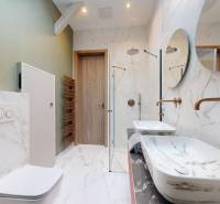 Luxury bathroom with a shower, marble sink, and bronze faucets in a 4-room apartment.