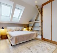 Bright bedroom with wood-patterned flooring and large skylights.
