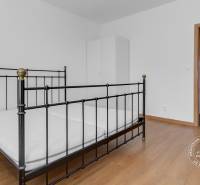 Bedroom of a 3-room apartment with a metal bed and a wooden decor floor.