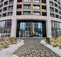 Building on Bottova Street in Bratislava – Old Town with commercial spaces and a sidewalk with snow.