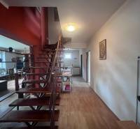 Interior of a family house with wooden stairs and a floor with a wooden decor.