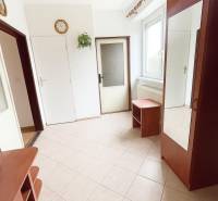 A bright hallway with tiles and wooden furniture in a family house.