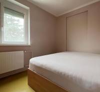 Bedroom in a family house with a simple bed, window, and radiator.
