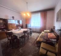 Interior of a family house with a dining table, sofa, and television.