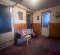 Interior of a family house with wooden paneling, a table, and a chair.