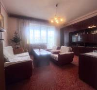 Living room in a family house with a red carpet and a sofa set.