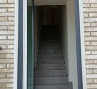 Entrance door with brick cladding and staircase to a 3-room apartment in Diakovce.