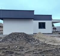 A family house in Žihárec during construction work with piles of soil and gravel.