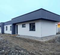 A family house in Žihárec with a white facade and a dark roof on a non-grassed plot.