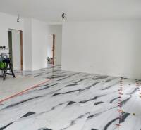 Interior of a family house with a marble-patterned floor and white walls.