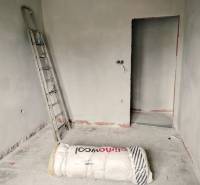 A construction room in a family house with a ladder and insulation material.