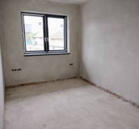 A place in a family house with plastered walls and a double window, without floor covering.