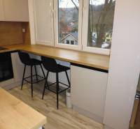 A kitchen with a table and black chairs in a 2-room apartment, floor with wooden decor.