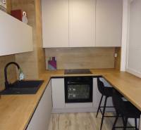 A kitchen with a wood-patterned floor in a two-room apartment, equipped with comfortable seating.