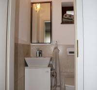 Bathroom with beige walls in a family house, with a sink and a mirror.