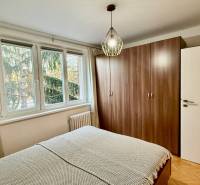 Bedroom in a 3-room apartment with a large wardrobe and a window overlooking the trees.