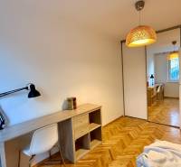A workspace with a wooden desk and a floor with a wooden decor in a 3-room apartment.