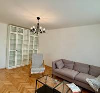 Living room in a 3-room apartment with a wooden decor floor, light furniture, and a sofa.