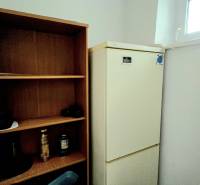 Refrigerator and wooden shelf in a 3-room apartment.