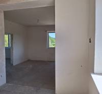 The interior of a family house with unfinished walls and a concrete floor.