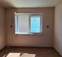 A room in a family house with an open window and a wooden decor floor.
