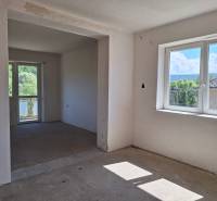 Room in a family house, large windows, view of the garden and surrounding trees.