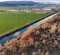 Recreational land by the river in Nová Ves nad Váhom, surrounded by nature and fields.