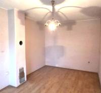 A room in a family house with a wooden decor floor and a pendant light.