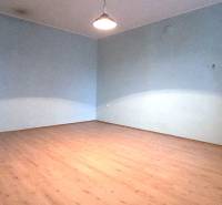 A room in a family house with a wooden decor floor and blue walls.