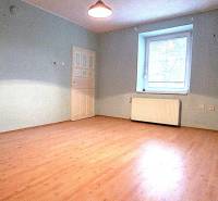 A room in a family house with a wooden decor floor and blue walls.