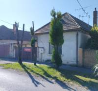 A family house in Reca with a wooden gate and a stone fence.