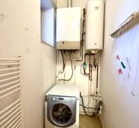Laundry room of a 4-room apartment with a boiler, water heater, and washing machine.