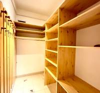 Storage space in a 4-room apartment with shelves and hanging rods.