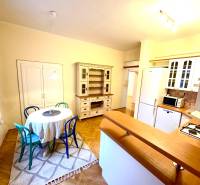 Dining room in a 4-room apartment with a round table and wooden decor flooring.