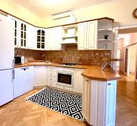 A kitchen in a 4-room apartment with white cabinets and a wood-patterned floor.