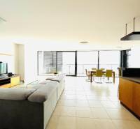 Living room with a large sofa in a 4-room apartment, smooth floor, glass walls.