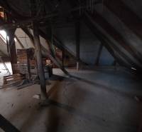 Attic space of a family house with wooden beams and stored crates.