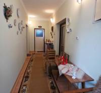 Hallway in a family house with decorative plates on the wall and a carpet.
