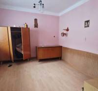 A room in a family house with pink walls, a wardrobe, and a wooden decor floor.